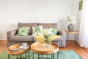 a living room with a couch and two tables at Casa da Avenida Lisboa in Lisbon