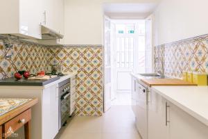 a kitchen with white countertops and a door into a room at Casa da Avenida Lisboa in Lisbon