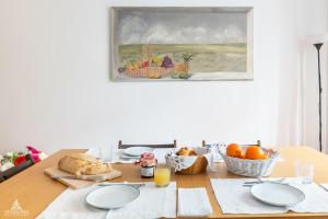a dining room table with a breakfast of bread and fruit at Casa da Avenida Lisboa in Lisbon
