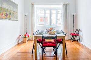a dining room with a table with red chairs at Casa da Avenida Lisboa in Lisbon