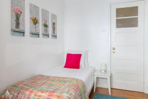 a bedroom with a bed with a red pillow on it at Casa da Avenida Lisboa in Lisbon