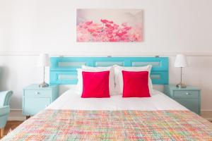 a bedroom with a bed with two red pillows at Casa da Avenida Lisboa in Lisbon