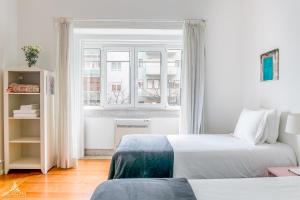 a bedroom with two beds and a window at Casa da Avenida Lisboa in Lisbon
