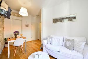 a living room with a white couch and a table at Apartments Toma in Split