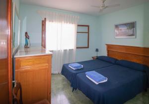 a bedroom with a blue bed with two towels on it at Camí de la Victòria in Alcudia