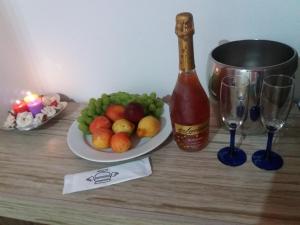 una mesa con una bandeja de fruta y una botella de vino en Minha casa é sua casa en Curitiba