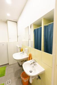 a bathroom with two sinks and two mirrors at Spicy Hostel in Budapest