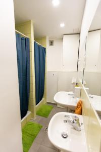 a bathroom with two sinks and two mirrors at Spicy Hostel in Budapest