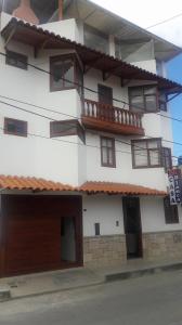 un gran edificio blanco con balcones y una calle en Hospedaje Casa Blanca Beach, en Los Baños del Inca