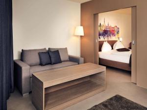 a living room with a couch and a bed at Hotel Mercure Graz City in Graz