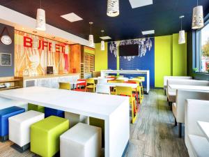a restaurant with brightly colored tables and chairs at ibis budget London Hounslow in Hounslow