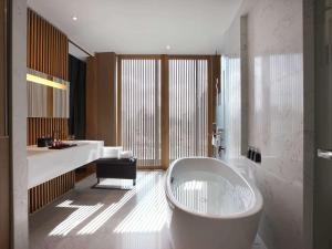 a bathroom with a large tub and a sink at SO/ Bangkok in Bangkok