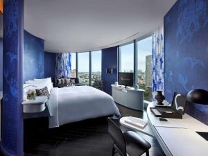 a hotel room with a large bed and a desk at SO/ Bangkok in Bangkok