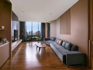 a living room with a couch and a table at SO/ Bangkok in Bangkok