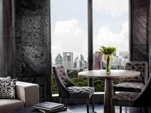 a room with a table and chairs and a window at SO/ Bangkok in Bangkok