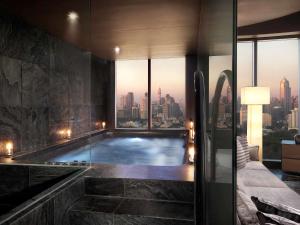 a swimming pool in a building with a view of the city at SO/ Bangkok in Bangkok