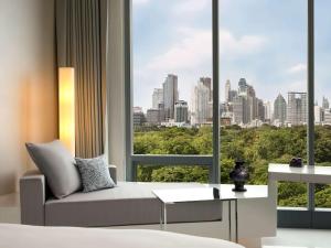 a room with a bed and a window with a city view at SO/ Bangkok in Bangkok