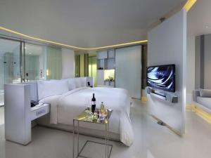 a hotel room with a bed and a tv at SO/ Bangkok in Bangkok