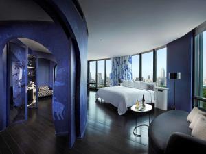 a hotel room with a bed and a couch at SO/ Bangkok in Bangkok