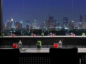 a table with a view of a city at night at SO/ Bangkok in Bangkok