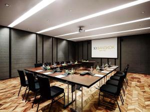 a conference room with a long table and black chairs at SO/ Bangkok in Bangkok