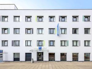 een wit gebouw met een vlag erop bij ibis budget Aachen City in Aken