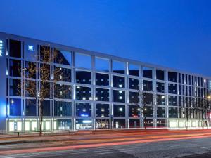 a large building with glass windows at night at ibis budget Hamburg City in Hamburg