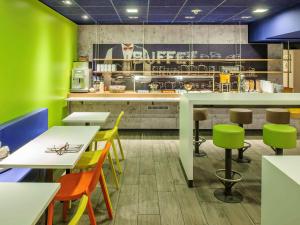 a restaurant with green walls and tables and chairs at ibis budget Hamburg City in Hamburg