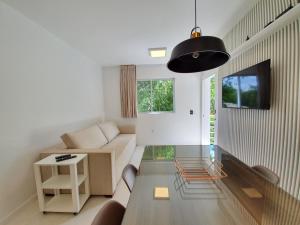 uma sala de estar com um sofá e uma mesa em Pousada Jurerê Rural em Florianópolis