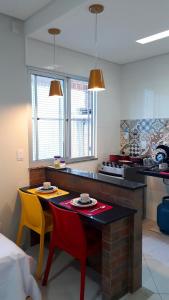 a kitchen with a table and two chairs and a counter at Hart Aparthotel Ltda in Salvador