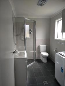 a bathroom with a shower and a toilet and a sink at Ashley's Retreat Umina Beach in Umina