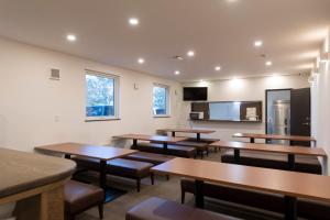 une salle de classe avec des tables et des chaises et un réfrigérateur dans l'établissement Niseko Wow Lodge, à Kutchan
