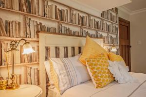 a bedroom with a bed and a wall of books at Pepper Tree Villa in Masterton