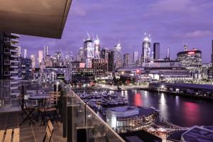 widok na miasto w nocy z przystanią w obiekcie AKOM AT Docklands w Melbourne