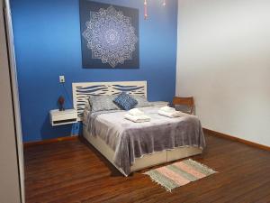 a bedroom with a bed with a blue wall at BELLA CASA 110m2 - CENTRO - PATIO - PARRILLA in Rosario