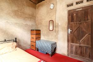Kasmiyem Homestay في Sermo: غرفة نوم بسرير وباب خشبي