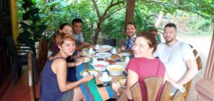 錫吉里亞的住宿－Sigiri Corridor Home Stay，一群坐在桌子旁吃食物的人