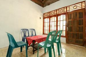 een tafel en stoelen in een kamer met een rode tafel en stoelen bij JIO Homestay in Sermo