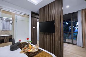 a living room with a television on a wall at S7 SUITES GANDARIA in Jakarta