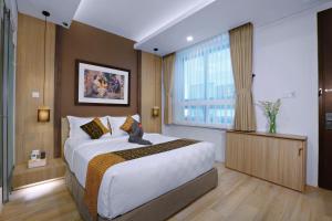 una camera da letto con un letto grande e una finestra di S7 SUITES GANDARIA a Giacarta
