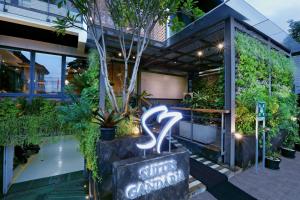 un cartello di fronte a un edificio con piante di S7 SUITES GANDARIA a Giacarta