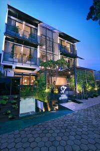 a building with a pool in front of it at night at S7 SUITES GANDARIA in Jakarta