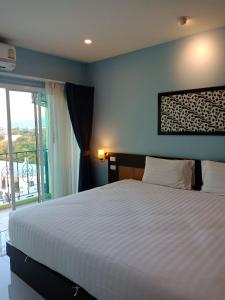 a bedroom with a large bed and a window at Phuket Chinoinn-SHAPlus Certified in Phuket Town