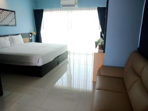 a bedroom with a bed and a window with a couch at Phuket Chinoinn-SHAPlus Certified in Phuket Town