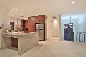 a large kitchen with wooden cabinets and a counter top at Villa Modica in Ipswich