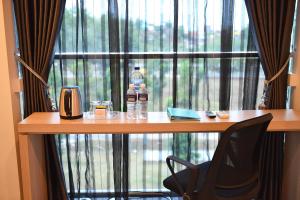 un tavolo di fronte a una finestra con bottiglie d'acqua di Fresh One Hotel a Batam Center