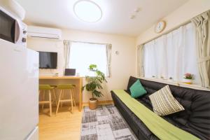 a living room with a couch and a desk at nestay villa tokyo otsuka in Tokyo