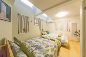 a bedroom with two beds and a window at nestay villa tokyo otsuka in Tokyo