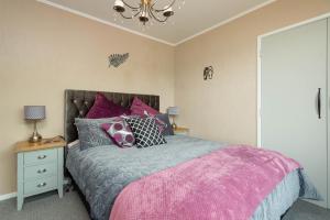 a bedroom with a bed and a chandelier at The Beautiful 4-6 Bdr ONEPU MOANA HOLIDAY HOME with Views & Spa-Pool in Opononi
