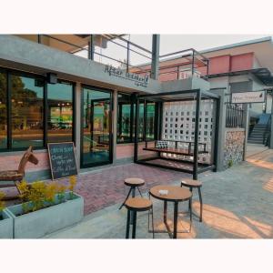 Pakarang Resort في ساتون: بضع الطاولات والكراسي أمام المبنى